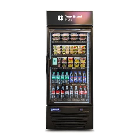 Black refrigerated display case with glass door stocked with beverages and packaged snacks, featuring Your Brand Here signage on top