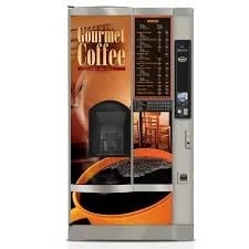 Gourmet coffee vending machine with black and orange design, display screen, and beverage dispensing slot.